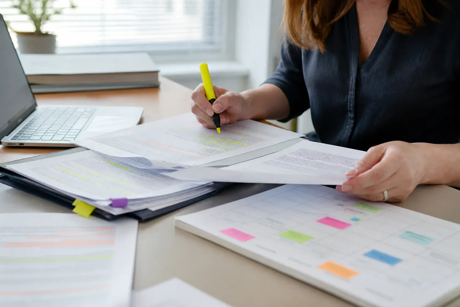 Éditrice comparant des documents sources et une liste de vérification datée